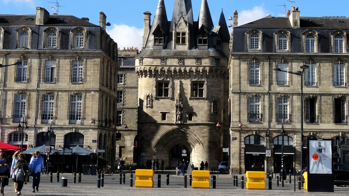The Grosse Cloche gate tower between historic stone buildings in Bordeaux, France