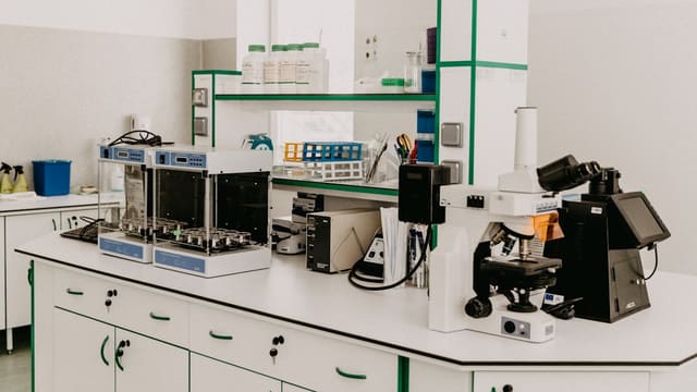Établi de laboratoire avec microscope et appareils d'analyse en salle lumineuse