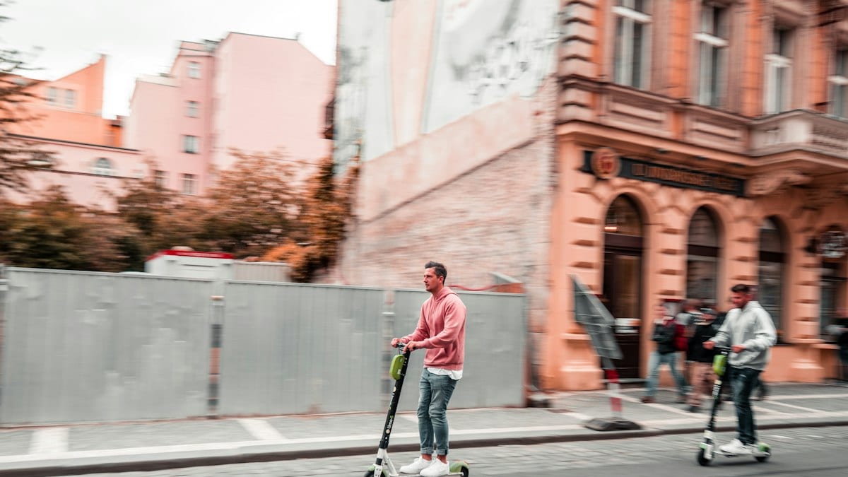 Deux hommes sur des trottinettes en plein jour