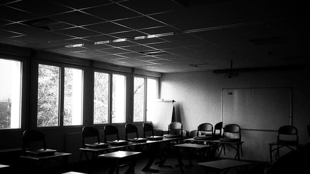 an empty classroom with desks and chairs