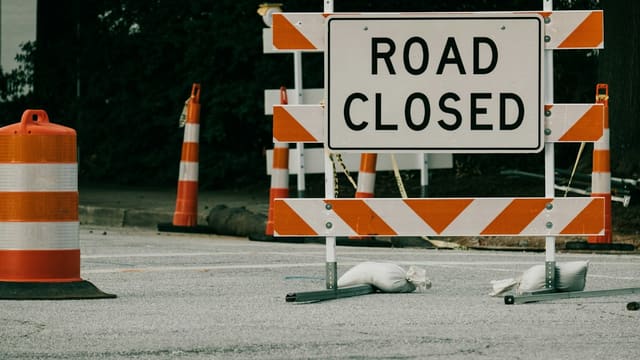 a road sign with orange cones