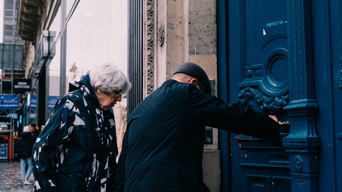 Deux personnes debout devant une porte bleue
