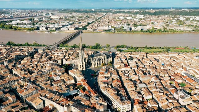 Vue aérienne de Bordeaux avec la Garonne et le pont de pierre, encadrant la ville et son fleuve nourricier du port