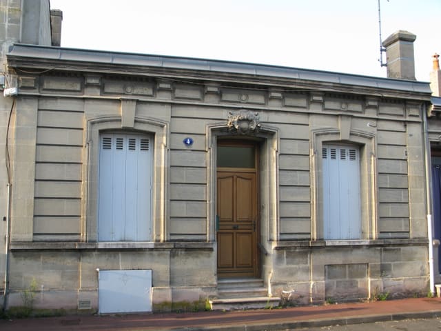 Façade d'une échoppe bordelaise double en pierre de taille, avec sa porte centrale et ses fenêtres symétriques.