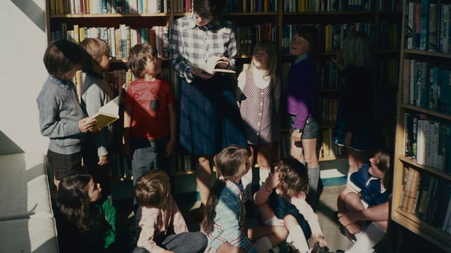 Groupe d'enfants devant une bibliothèque