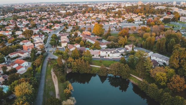Vue aérienne d'un quartier résidentiel arboré autour d'un plan d'eau, aux couleurs d'automne