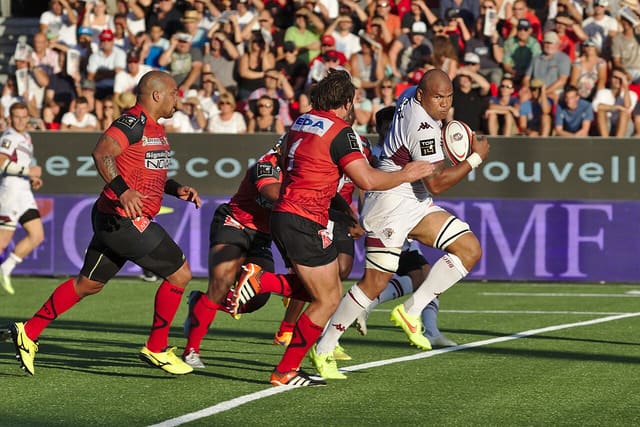 Joueur de rugby en mêlée dépassant ligne de gain