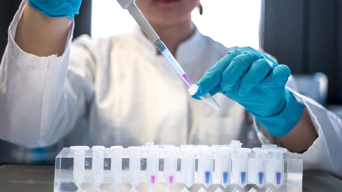 Scientifique utilisant pipette avec tubes à essai