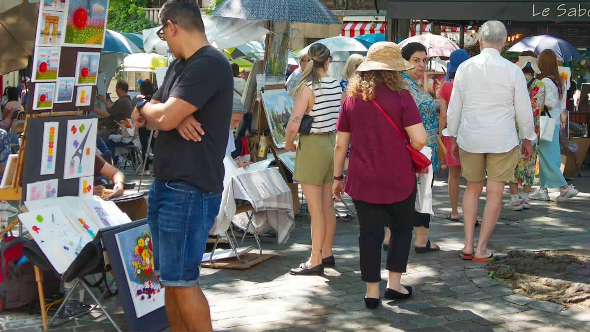 Public examinant de l'art à marché en plein air